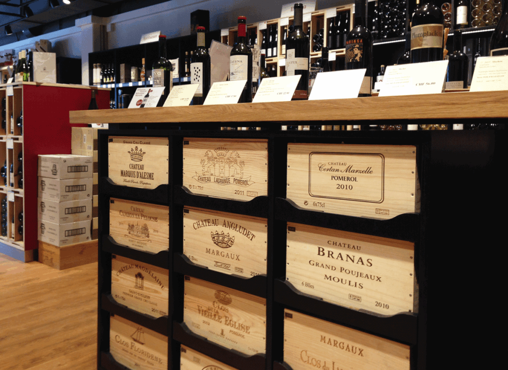Schwarzes Regal mit eingelegten Weinkisten aus Holz, Flaschen zur Präsentation obenauf