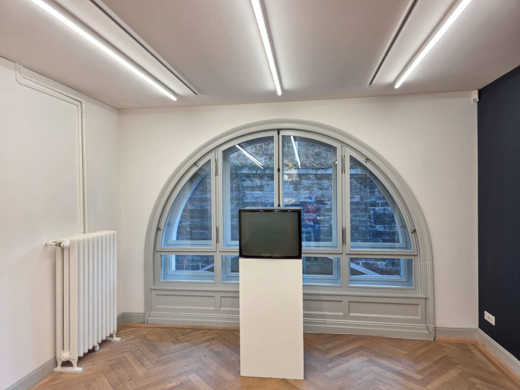 Moderner Raum im Altbau mit grossem Rundbogenfenster und Fischgrät Parkettboden