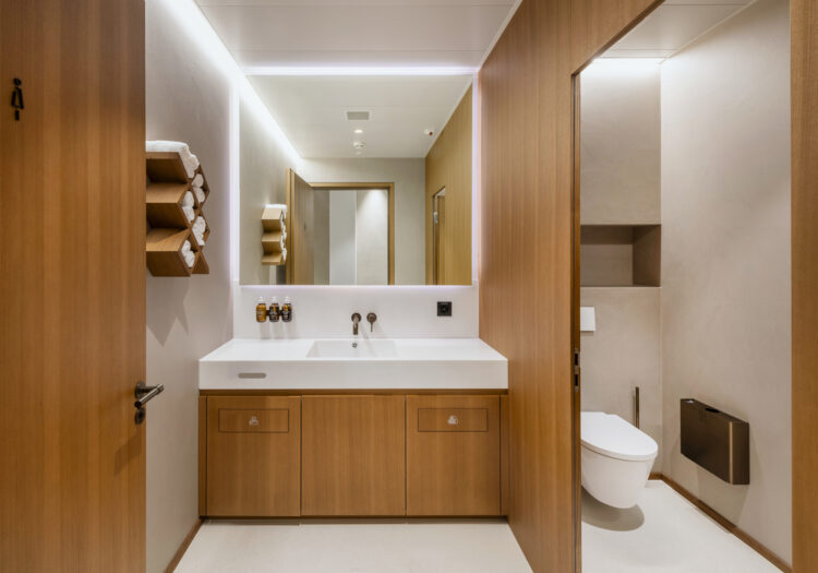 WC-Anlage mit Waschtisch, Spiegeln und Holzverkleidung, Teil eines hochwertigen Innenausbaus durch die Schreinerei R. Brunner AG Zürich.
